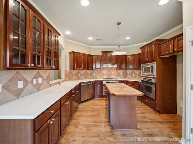 kitchen featuring under cabinet range hood, light wood-type flooring, appliances with stainless steel finishes, and butcher block counters