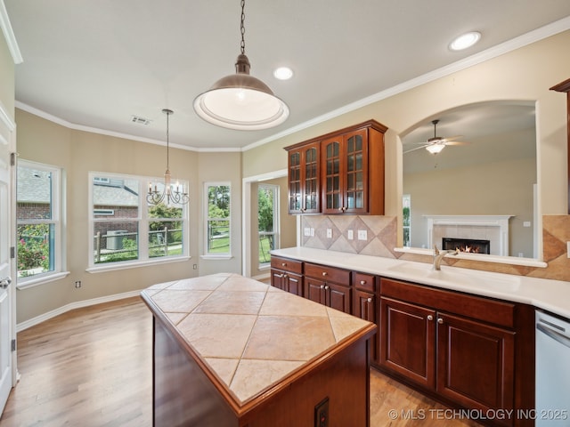 kitchen featuring light countertops, visible vents, glass insert cabinets, a sink, and dishwasher