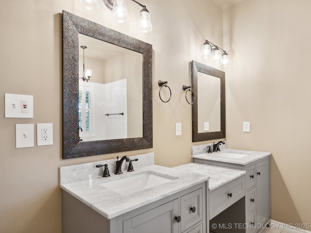 full bathroom featuring walk in shower, two vanities, and a sink