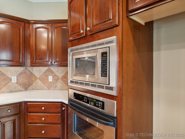 kitchen featuring backsplash, appliances with stainless steel finishes, and light countertops