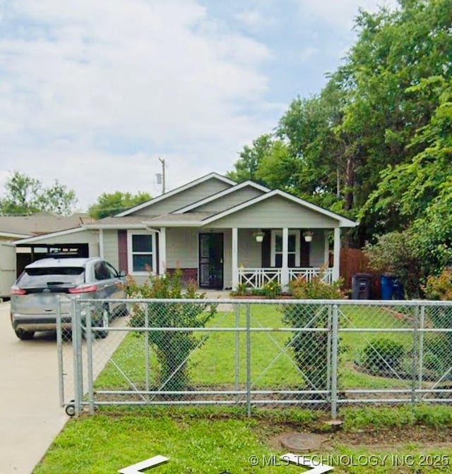 view of front of home with a fenced front yard, covered porch, driveway, a carport, and a front lawn