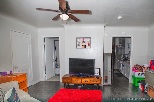 living area featuring dark floors and a ceiling fan