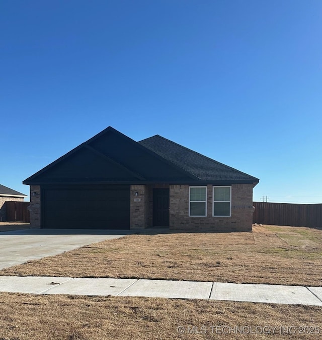 ranch-style house featuring brick siding, an attached garage, driveway, and fence