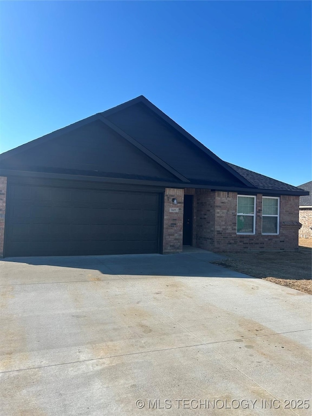 ranch-style house featuring brick siding, an attached garage, and concrete driveway