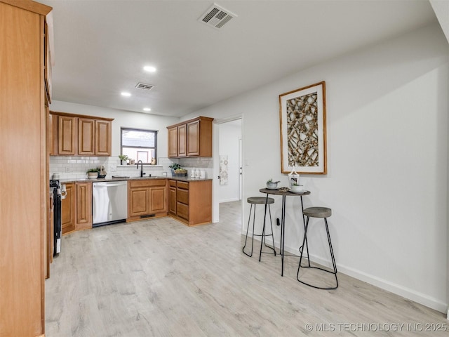 kitchen with backsplash, visible vents, light countertops, and stainless steel dishwasher