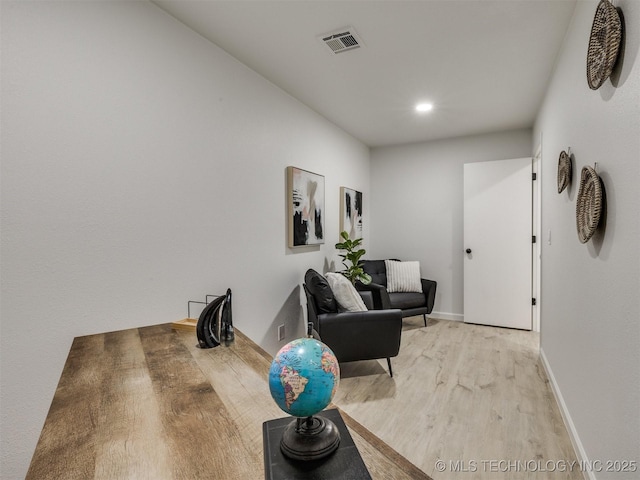 sitting room with visible vents, light wood-style flooring, and baseboards