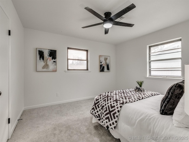 bedroom featuring light colored carpet, baseboards, and multiple windows