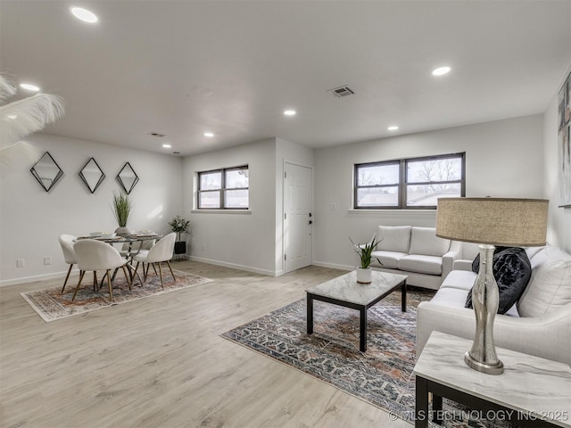 living area featuring recessed lighting, baseboards, visible vents, and light wood finished floors