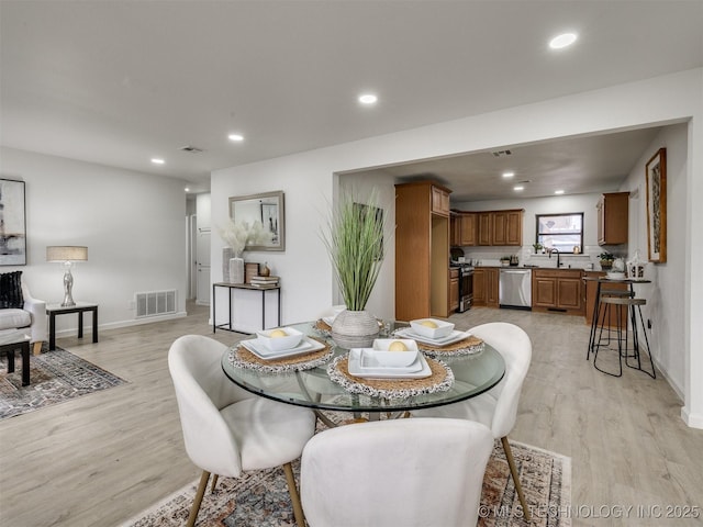 dining area with light wood-style floors, recessed lighting, and visible vents