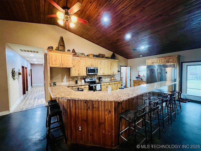 kitchen featuring wood ceiling, stainless steel appliances, visible vents, and a kitchen breakfast bar