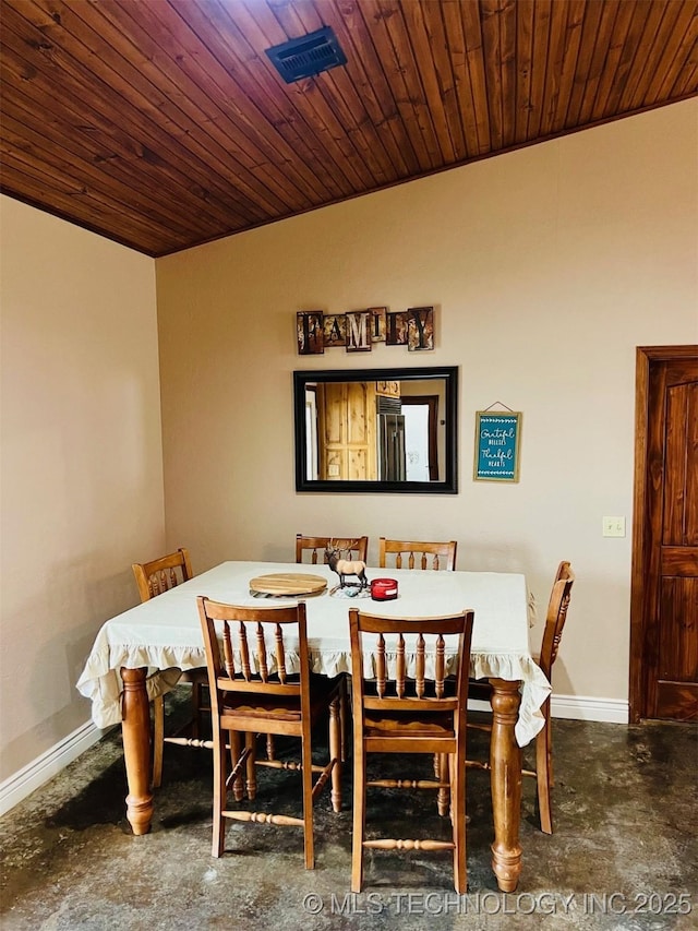 dining room featuring lofted ceiling, concrete floors, wooden ceiling, and baseboards