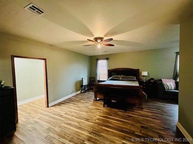 bedroom with visible vents, ceiling fan, baseboards, and wood finished floors