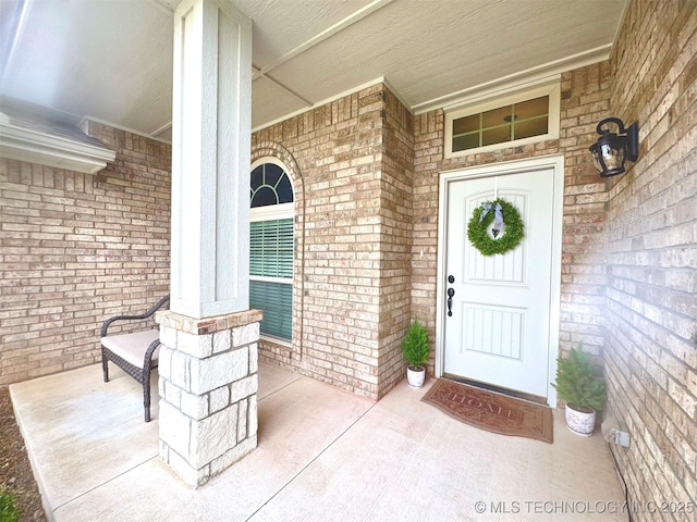 doorway to property featuring brick siding