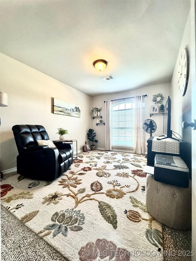 carpeted living room featuring visible vents and baseboards