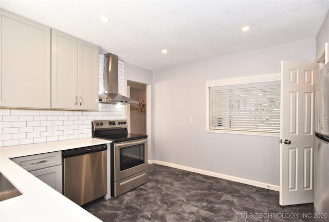 kitchen featuring tasteful backsplash, gray cabinets, stainless steel appliances, light countertops, and wall chimney range hood