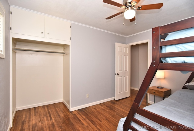 bedroom with dark wood-style floors, a closet, ornamental molding, and baseboards