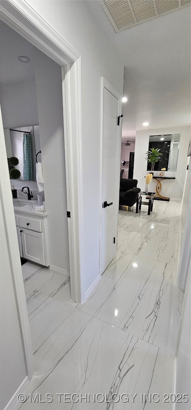 hall with marble finish floor, visible vents, and baseboards