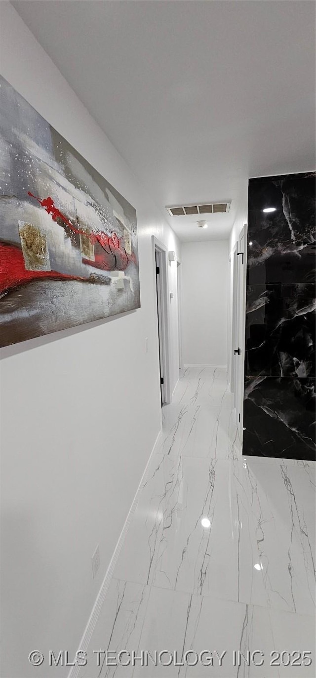 hall with marble finish floor, baseboards, and visible vents