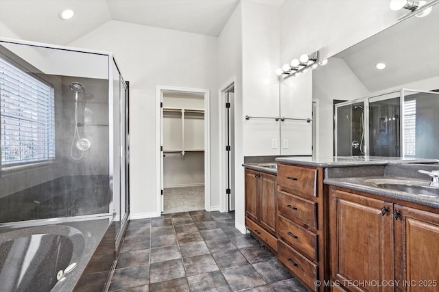 full bath featuring lofted ceiling, a shower stall, a spacious closet, and vanity