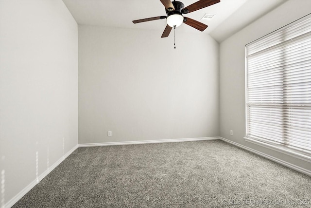 carpeted empty room featuring baseboards, vaulted ceiling, visible vents, and ceiling fan