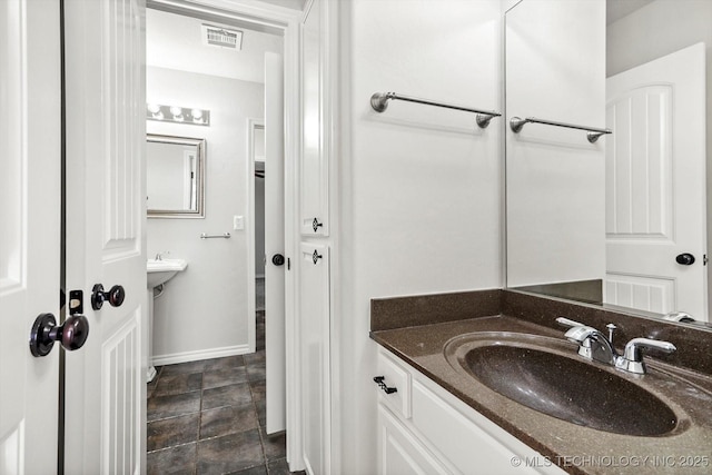 bathroom with a sink, visible vents, and baseboards