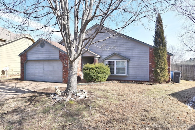 ranch-style house featuring a garage, driveway, and fence