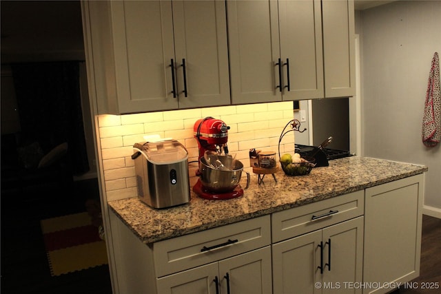 kitchen with gray cabinets, dark wood finished floors, decorative backsplash, and light stone countertops