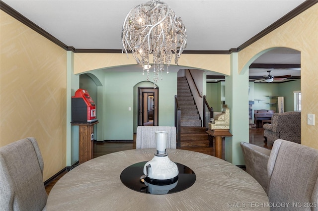 dining room with baseboards, stairs, arched walkways, and crown molding