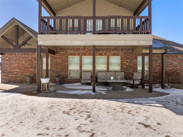 rear view of house with a balcony, an outdoor hangout area, roof with shingles, a patio area, and brick siding