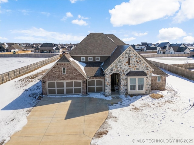 view of front of property with a residential view, driveway, an attached garage, and fence