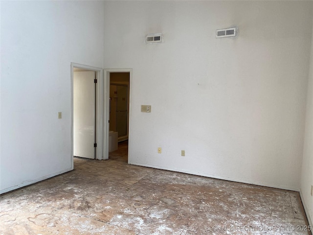 empty room with a towering ceiling and visible vents