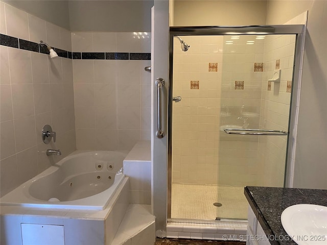 bathroom featuring a jetted tub, a shower stall, and vanity