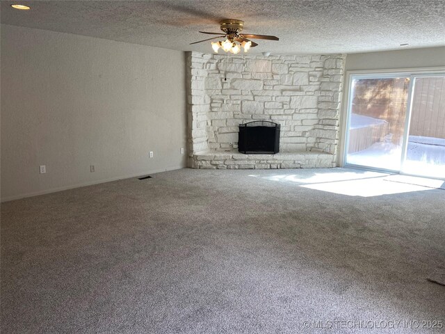 unfurnished living room with carpet flooring, a fireplace, a textured ceiling, and ceiling fan