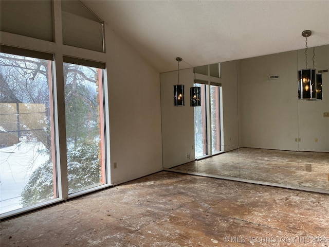 unfurnished dining area with visible vents and vaulted ceiling