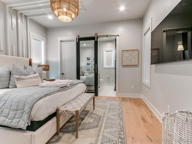 bedroom featuring baseboards, a barn door, recessed lighting, and light wood-style floors