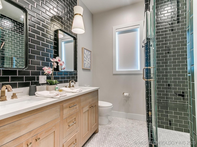 full bath with a sink, a shower stall, toilet, and double vanity