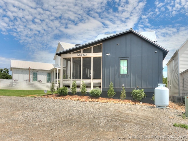 view of side of home featuring board and batten siding and a sunroom