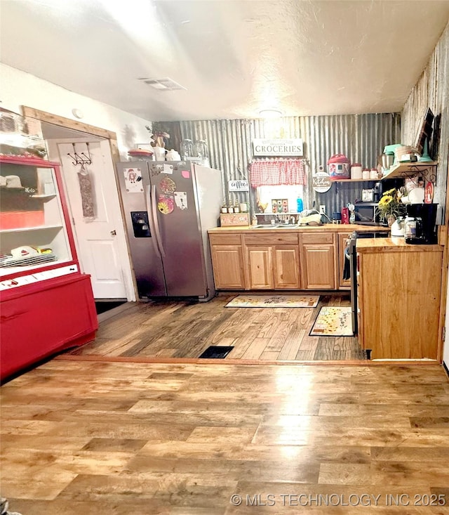 kitchen with visible vents, stainless steel refrigerator with ice dispenser, and wood finished floors