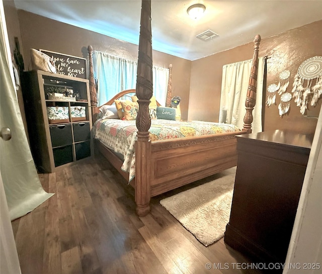 bedroom featuring wood finished floors and visible vents