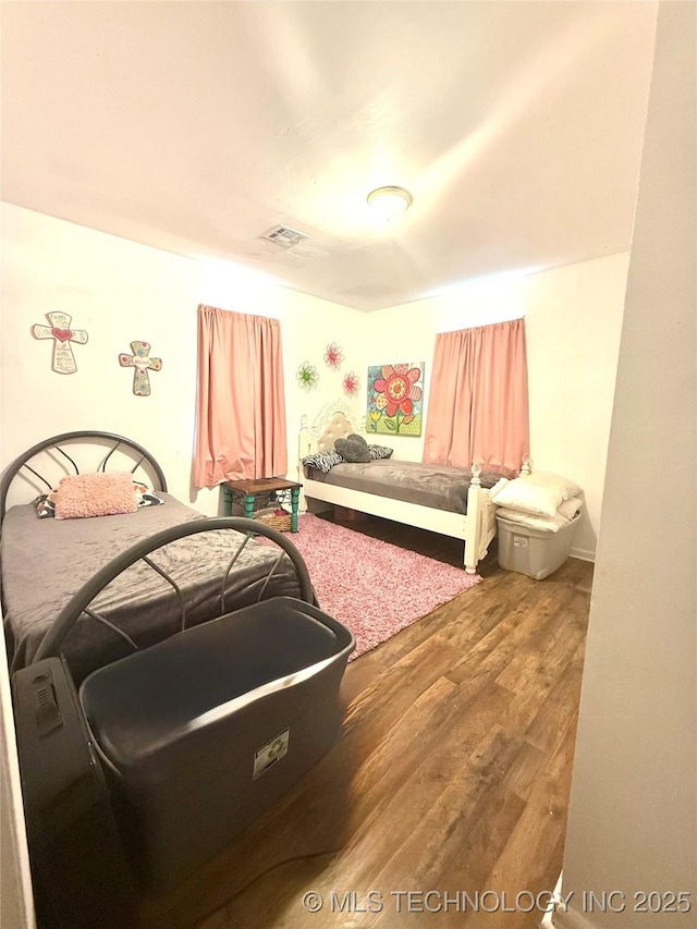 bedroom with wood finished floors and visible vents