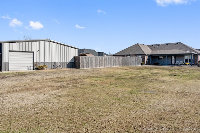 view of yard featuring a detached garage and fence