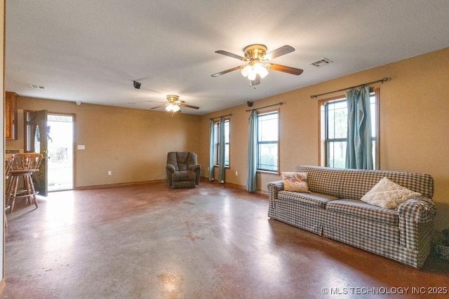 living room with a ceiling fan, baseboards, visible vents, and concrete flooring