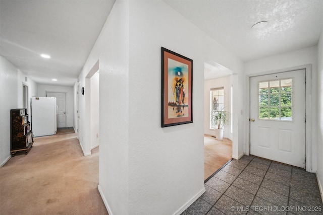 entryway with light carpet, recessed lighting, and baseboards