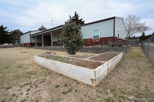 view of front of house featuring fence, a vegetable garden, and a front lawn