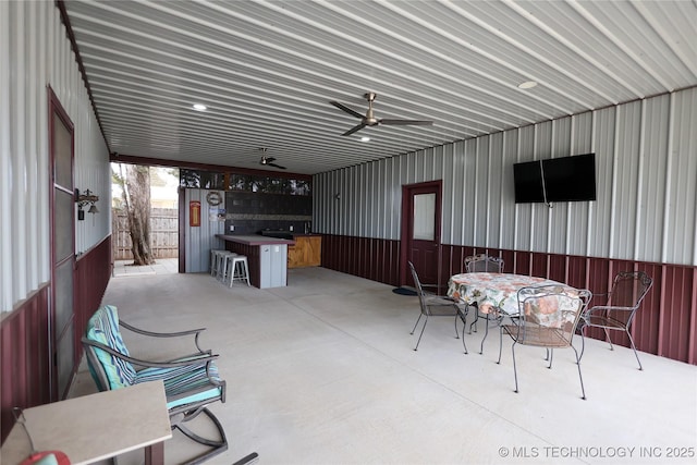 view of patio with outdoor dining area, an outdoor bar, and a ceiling fan