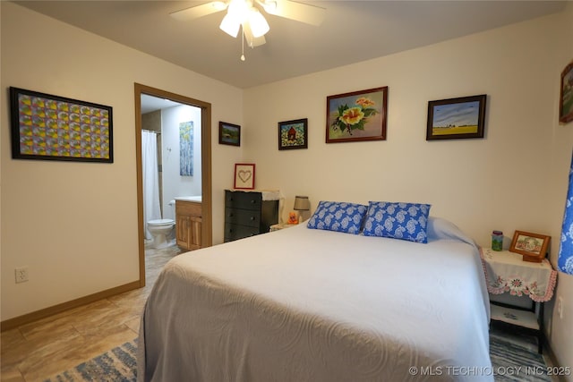 bedroom featuring a ceiling fan, ensuite bath, and baseboards