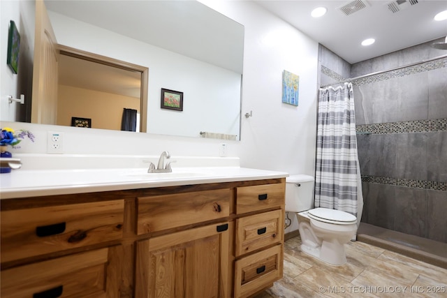 full bath with visible vents, vanity, toilet, and tiled shower