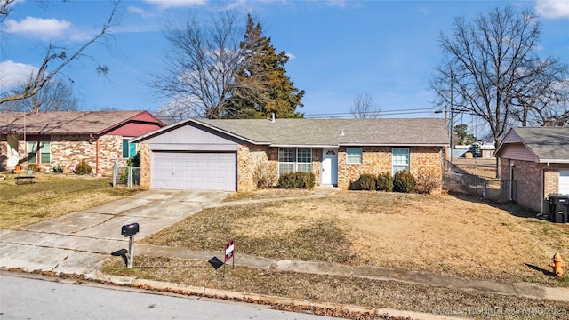 single story home featuring a garage, concrete driveway, brick siding, and a front lawn