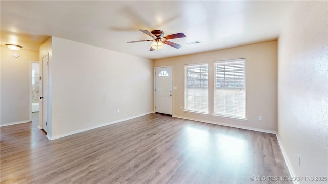 interior space featuring light wood-style floors, baseboards, and visible vents