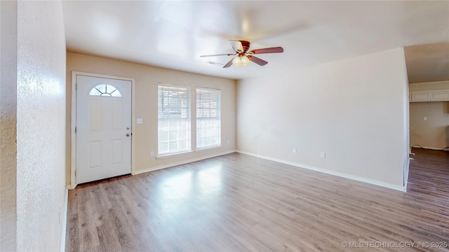 entryway featuring visible vents, light wood-type flooring, a ceiling fan, and baseboards